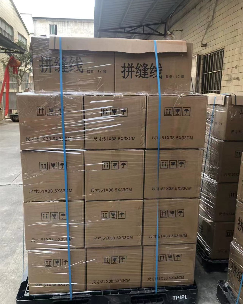 Cartons of veneer splicing thread secured on a shipping pallet
